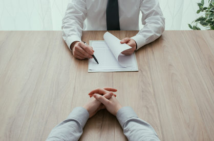 Examiner reading a resume during a job interview, employment and recruitment concept, point of view shot